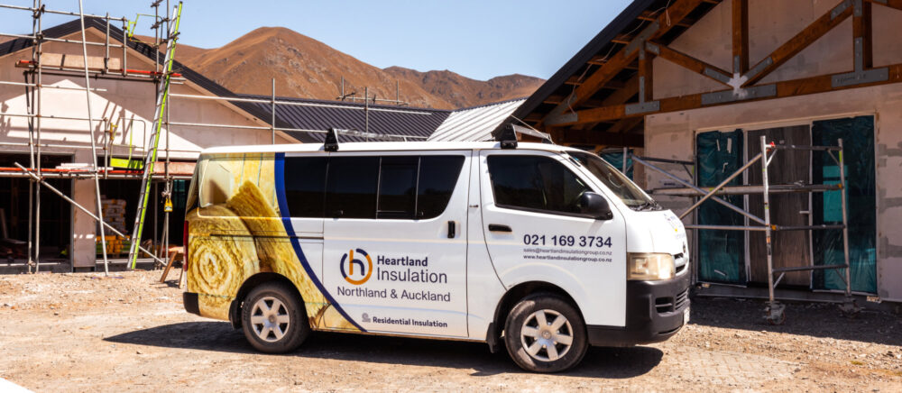 Heartland Insulation Van in front of building site